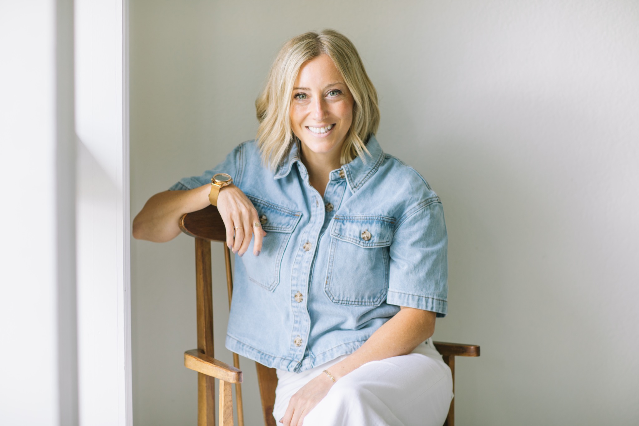 Rachael Kiehne smiling while seated in a wooden chair
